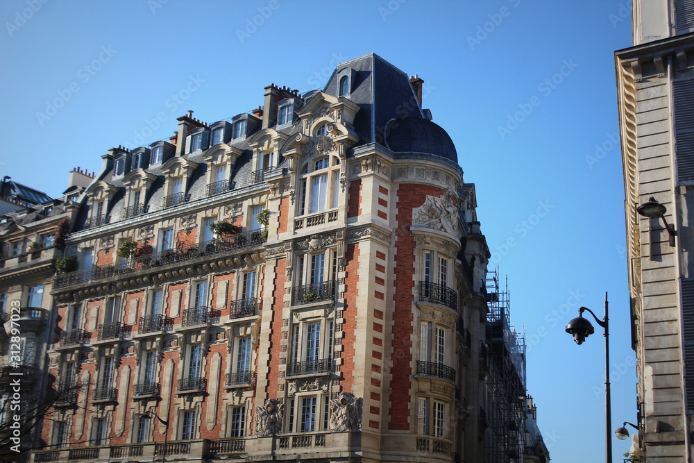 Fototapeta premium Typical Parisian architecture in the centre of Paris, France. Decorative appartment building on spring day.