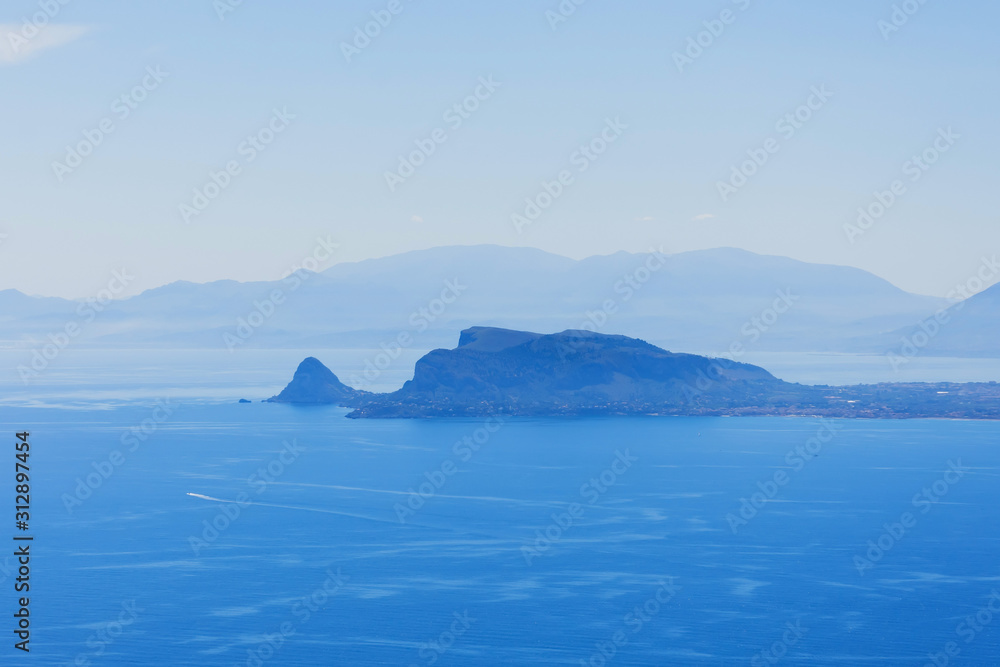 Aerial view of the horizon with islands and rocks in the blue sea.
