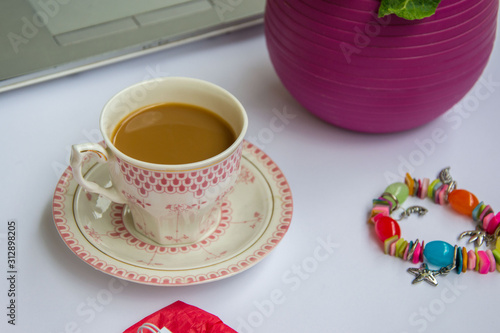 Coffee in the office  close-up of the desk with beautiful decorated cup with hot beverage  business concept