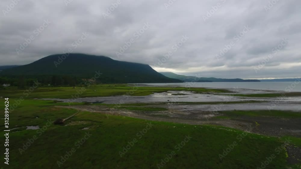 Overcast day as a drone shots an aerial shot over the water of the shore line. Overcast day as a drone shots an aerial shot over the water of the shore line.