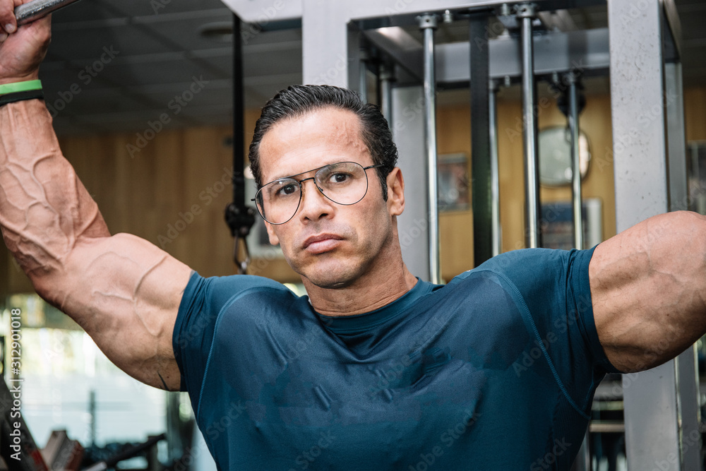 Detail of the face of a man doing strength with glasses doing bodybuilding exercises - obrazy, fototapety, plakaty 