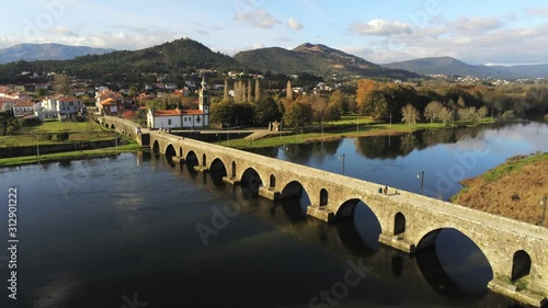 Up and over Ponte de Lima bridge reflecting in calm water. photo
