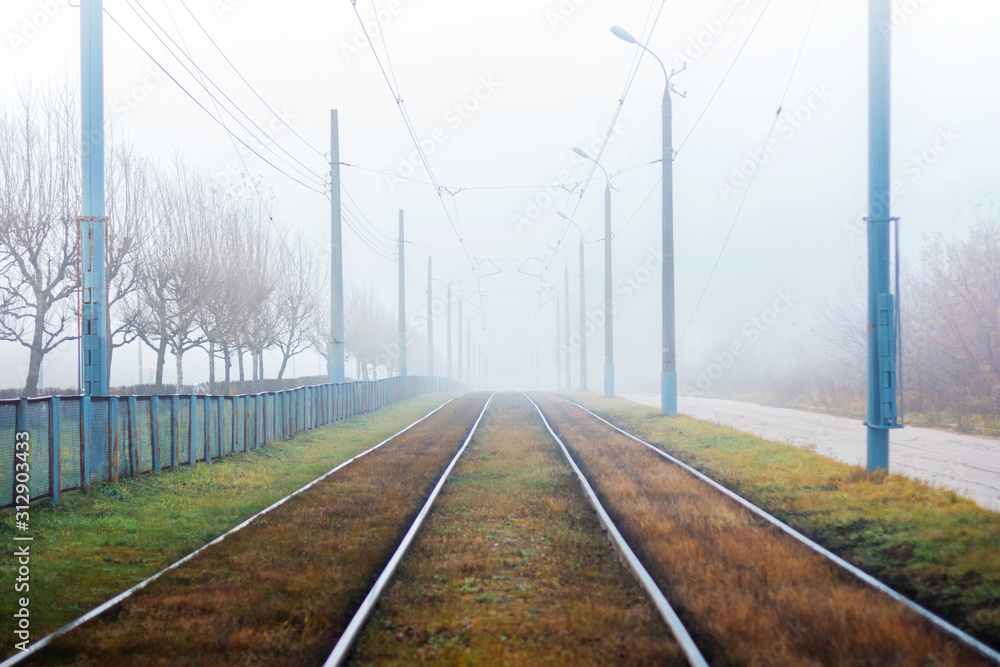 Railway in the fog. Empty street on autumn morning