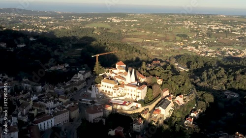 Aerial Views of the ancient city of Sintra and Palacio de Pena, Portugal. Sintra National Palace up on the hill in a sunny day. Drone footage track out