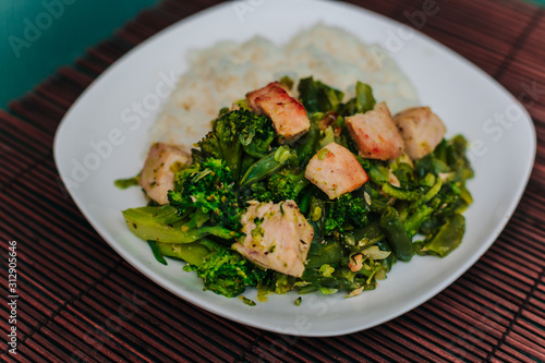 White plate with broccoli and beans stewed vegetables with chicken.