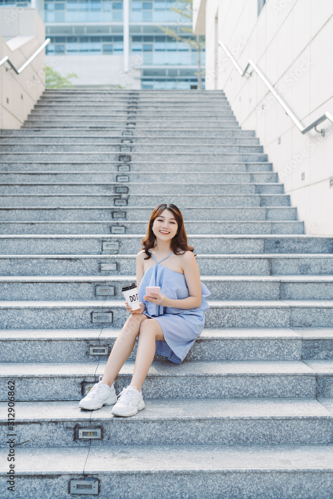Beautiful young Asian woman sitting at outdoor stair and using smartphone. Lifestyle of modern female. Beautiful young Asian woman sitting at outdoor stair and using smartphone. Lifestyle of modern female.