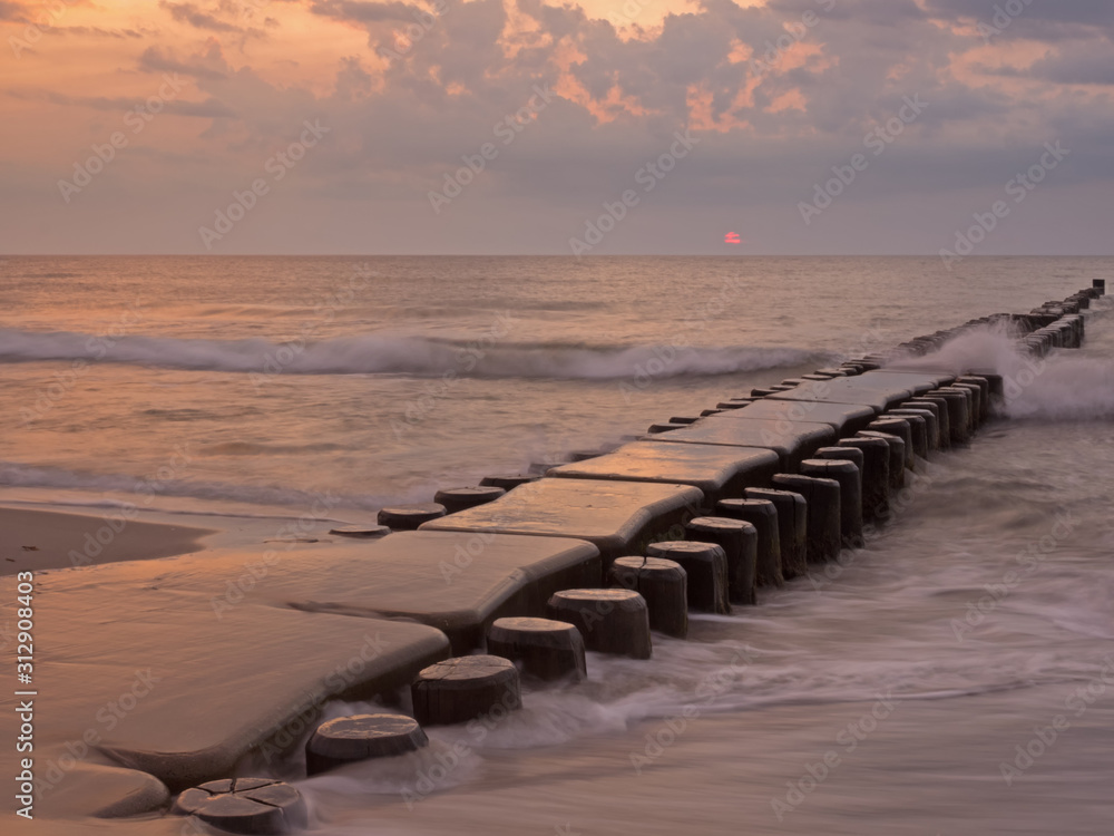 Fototapeta premium Buhne in der Ostsee bei Ahrenshoop, Mecklenburg-Vorpommern, bei Sonnenuntergang