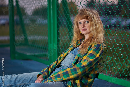 Portrait of redhead ginger girl weared in casual style denim jumpsuit and plaid shirt