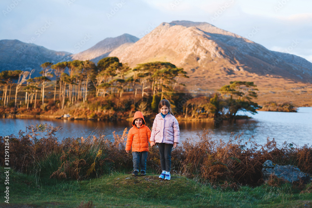 children on hill at lake