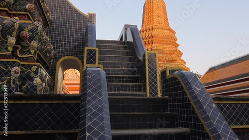 Bangkok / Thailand - July 20, 2014: A camera tilts up to the top of a beautifully decorated stupa in a famous Buddhist temple. (ID: 312913049)