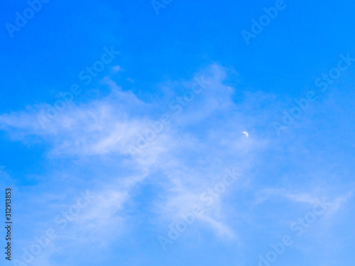 cloudy sky in day time with haft moon, blue sky background
