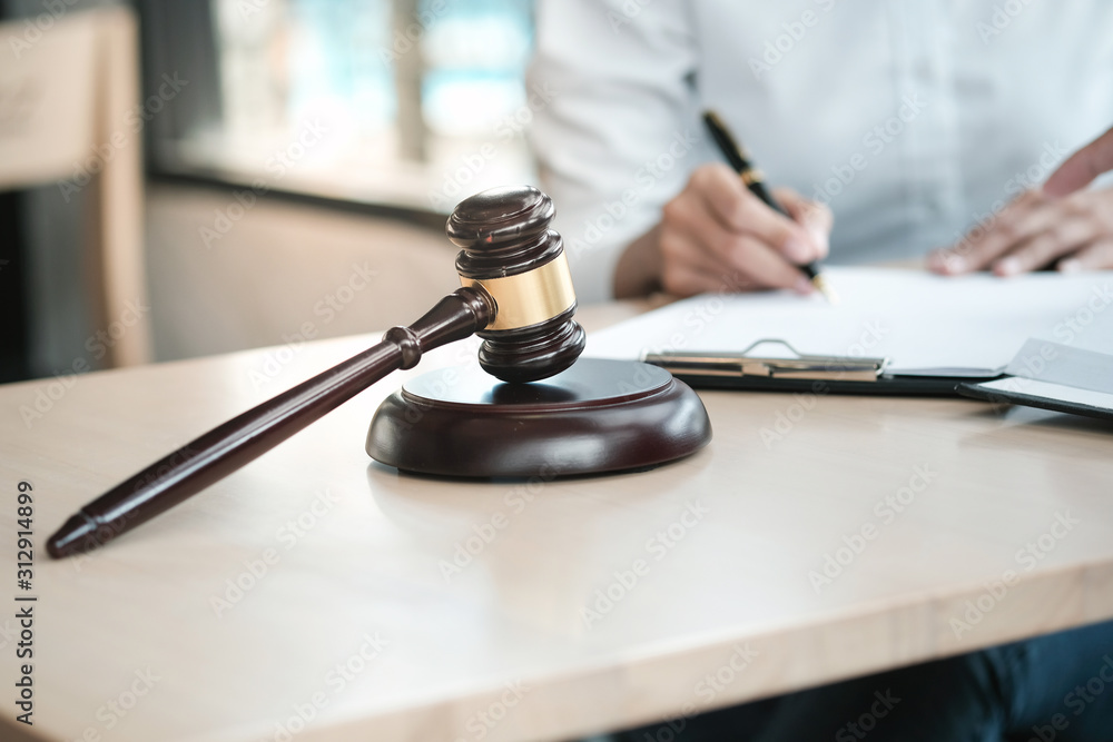 Legal counsel presents to the client a signed contract with gavel and legal law. justice and lawyer concept. Legal counsel presents to the client a signed contract with gavel and legal law. justice and lawyer concept.