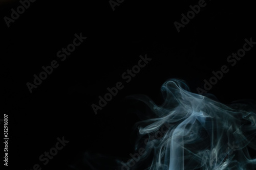 Beautiful abstract blue smoke with copy space on black background. Smoke background for art design or drawing. Abstract figure of the smoke