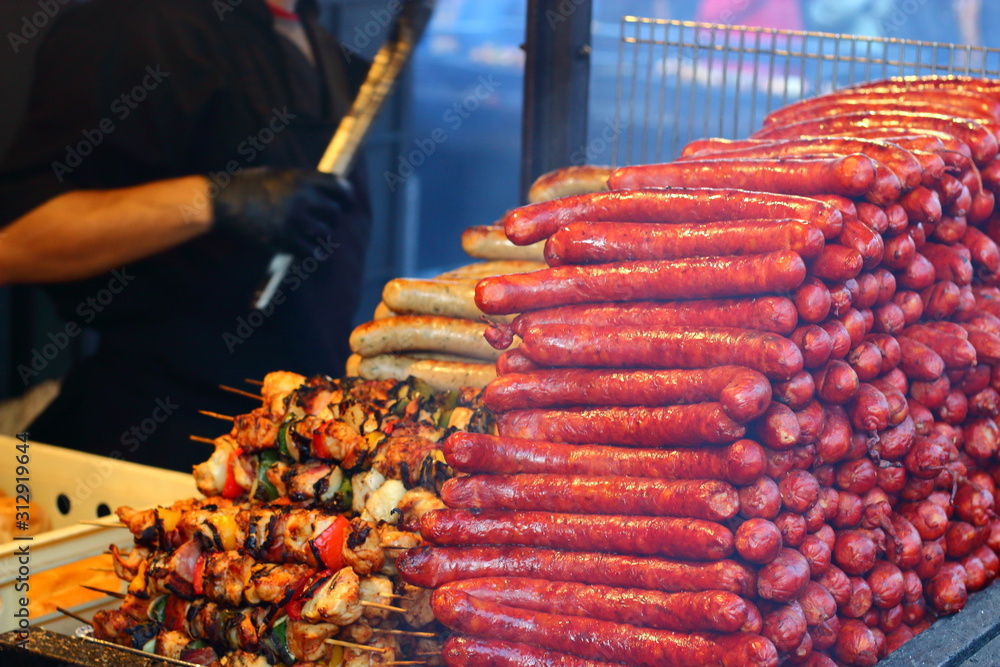 Street food. A hill of fried, hot, mouth-watering, juicy sausages and barbecue.