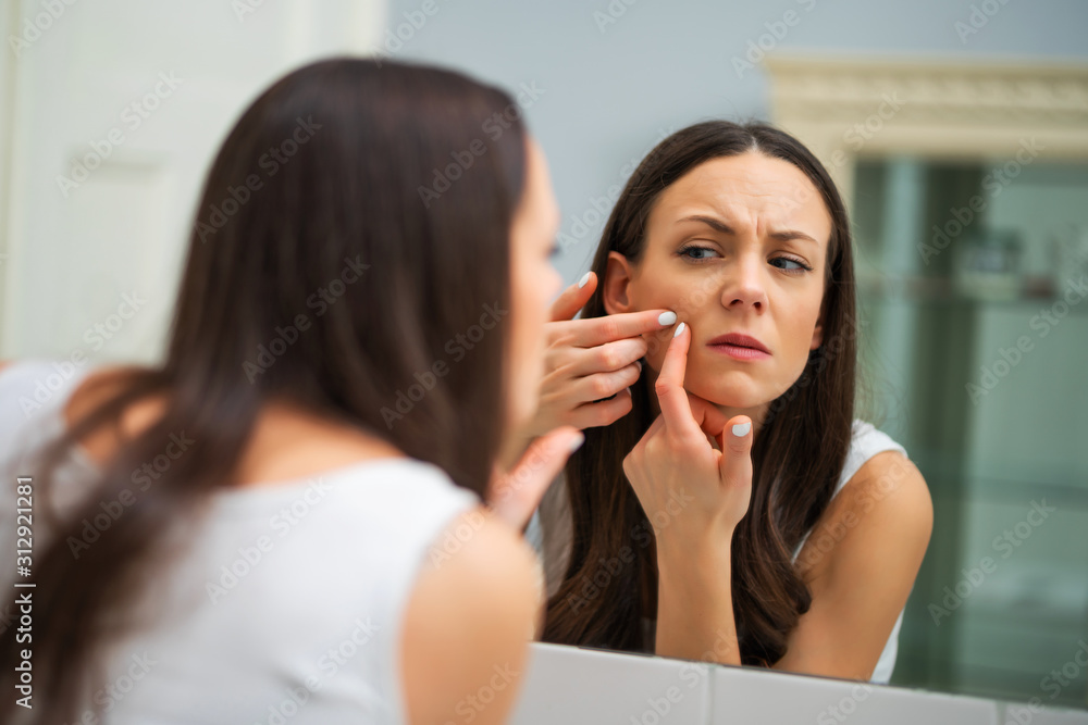 Young woman is squeezing pimple in the bathroom. Young woman is squeezing pimple in the bathroom.