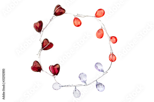 A wreath of silver sprigs with glass burgundy hearts, red and purple droplets isolated on white background