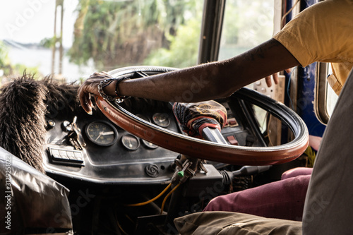 A driver drives a bus in Asia. Close-up of the steering wheel and hands. photo