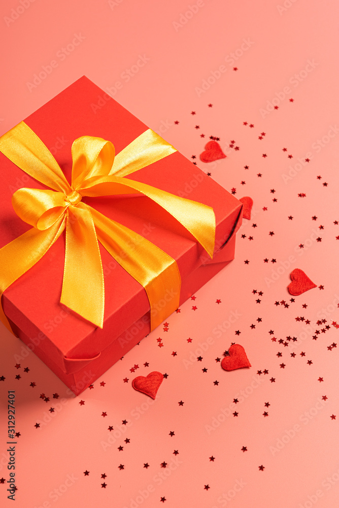 red box tied with a gold ribbon. the ribbon is tied on a box in the form of a beautiful bow. holiday gift concept red box tied with a gold ribbon. the ribbon is tied on a box in the form of a beautiful bow. holiday gift concept