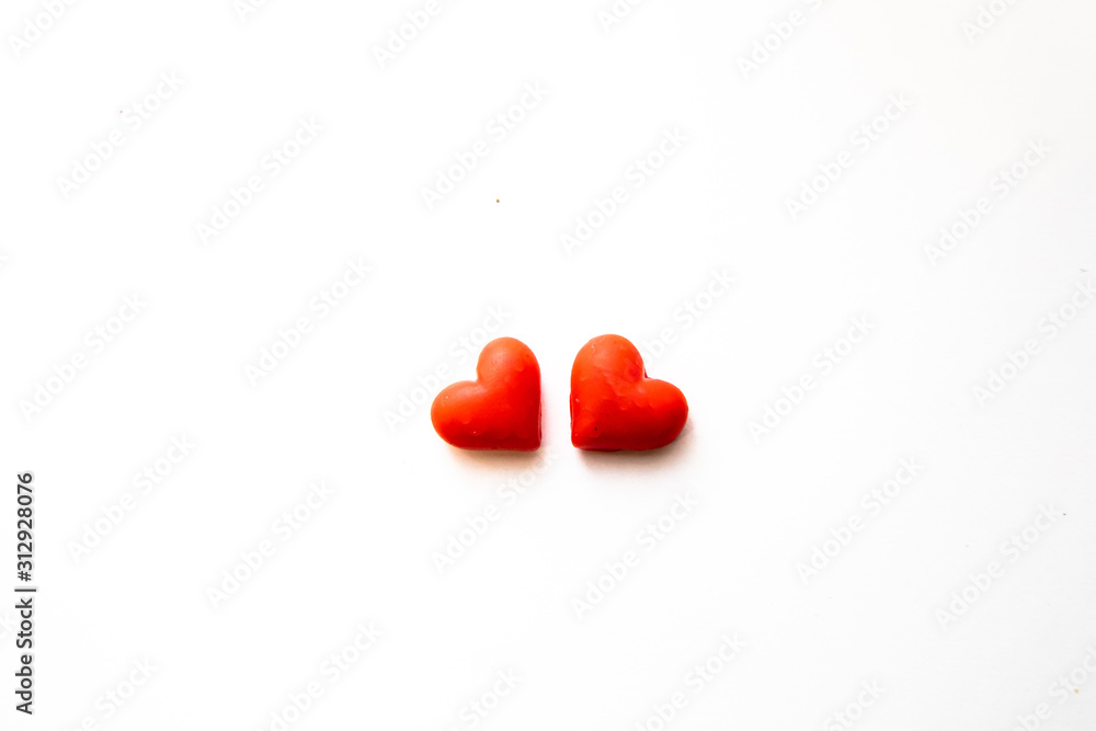 Fototapeta premium chocolate hearts. Two covered in red on a white background