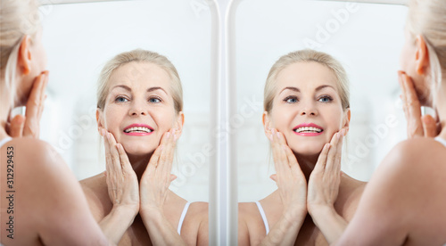 Before and after. Middle aged woman looking at wrinkles in mirror. Plastic surgery and collagen injections. Makeup. Macro face. Selective focus
