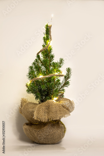 Beautiful little christmas tree with garland on a white background.