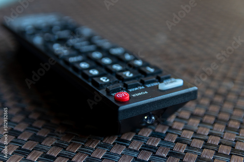 TV remote control withouth brand name with selective focus on red power button