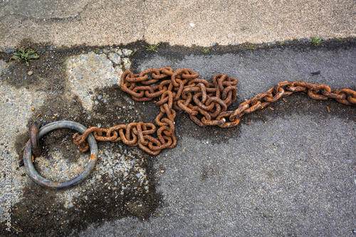 Rusty iron chain on concrete dock at a jetty