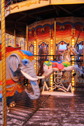 Christmas  Marry-Go-Round Carousel  with horses and elephant.  Garland lights on.