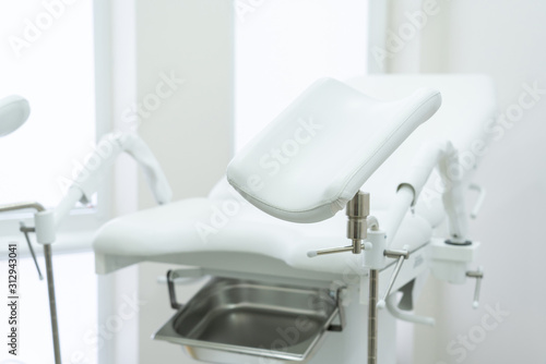 Empty white gynecological chair in modern medical center photo