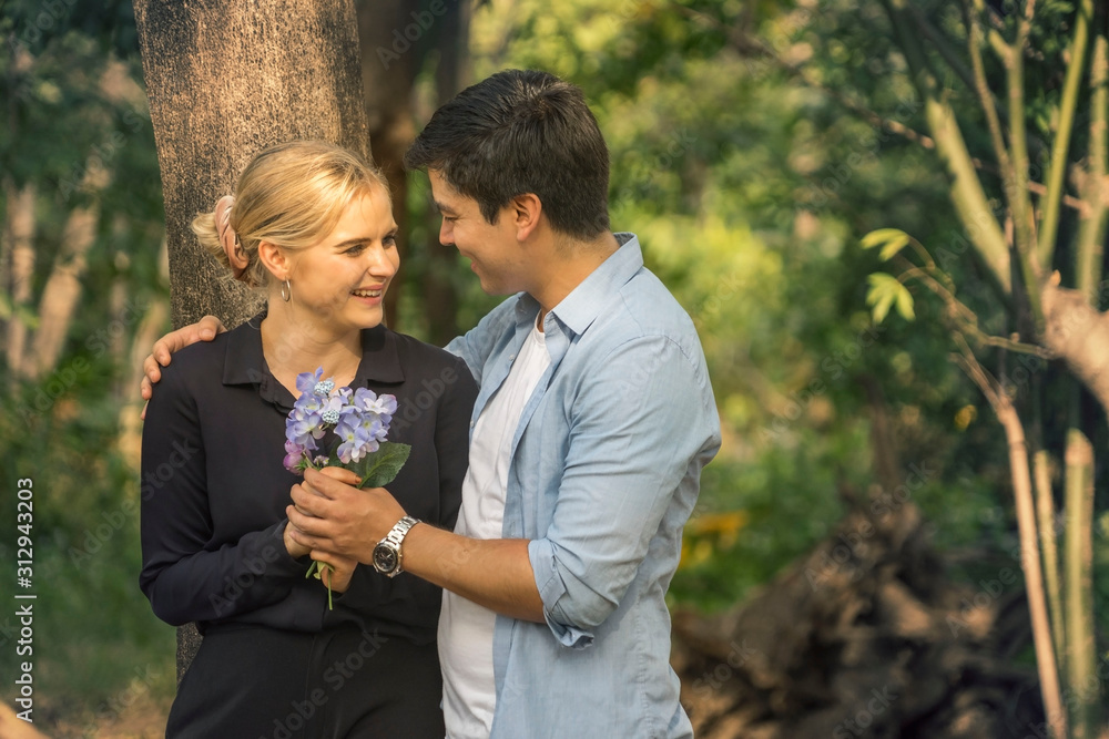 Portrait of a happy young couple in love Standing and spending time together in park.The concept of youth, love and Valentines day . Portrait of a happy young couple in love Standing and spending time together in park.The concept of youth, love and Valentines day .