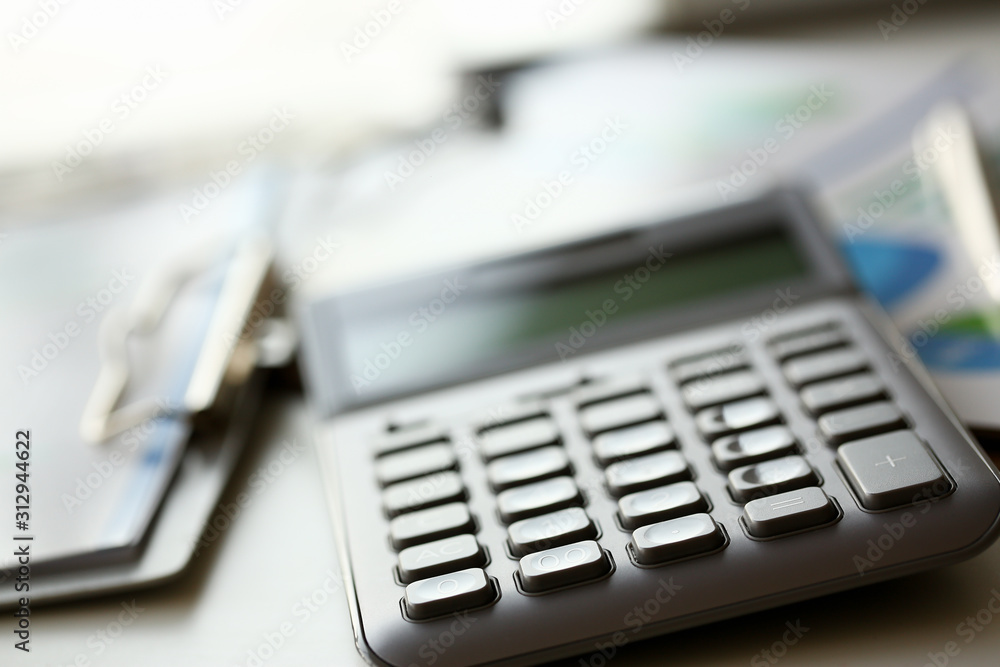 Silver calculator with gray keyboard is lying Silver calculator with gray keyboard is lying