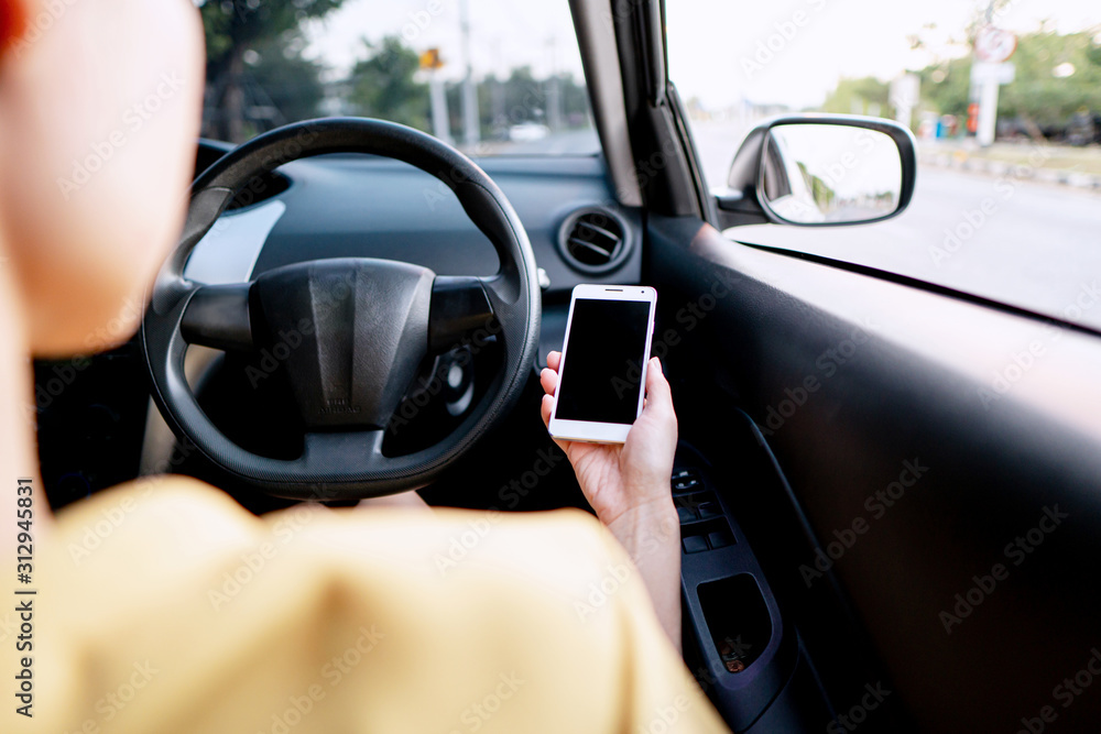 Woman looking at mobile phone while driving
