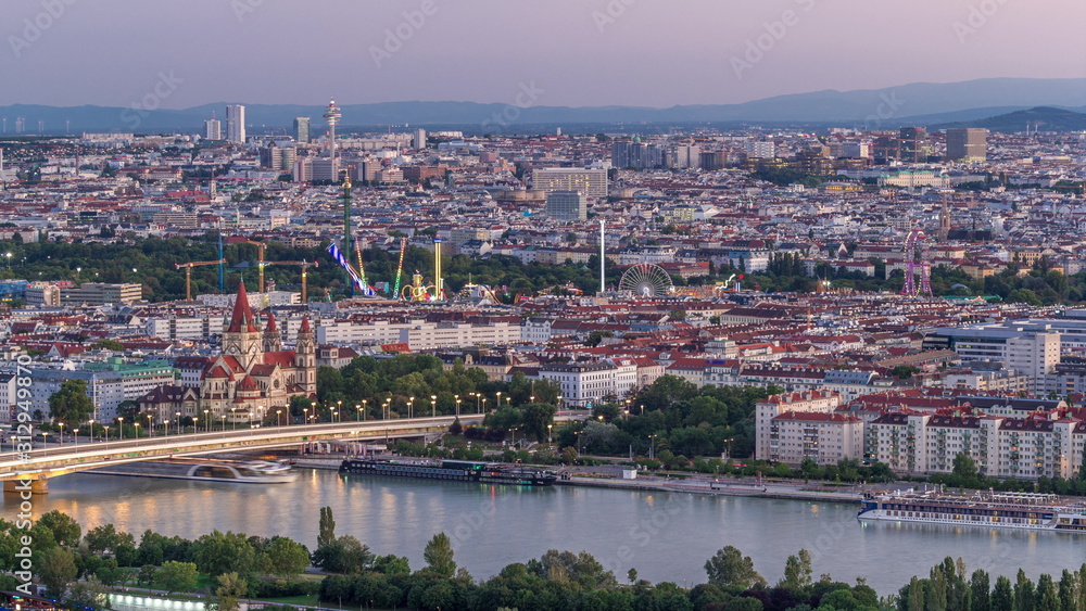 Aerial panoramic view over Vienna city with skyscrapers, historic buildings and a riverside promenade day to night timelapse in Austria.