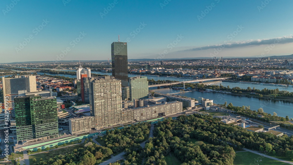 Fototapeta premium Aerial panoramic view of Vienna city with skyscrapers, historic buildings and a riverside promenade timelapse in Austria.