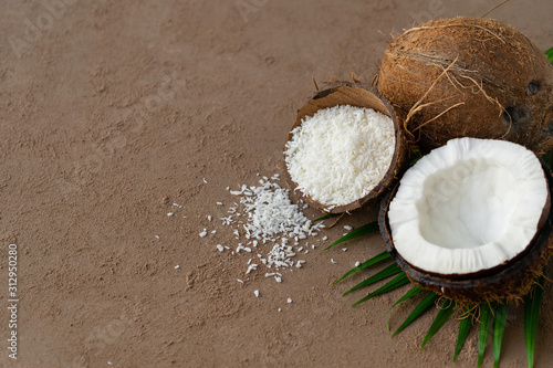 fresh half cut and whole coconuts with coconut flakes on background photo