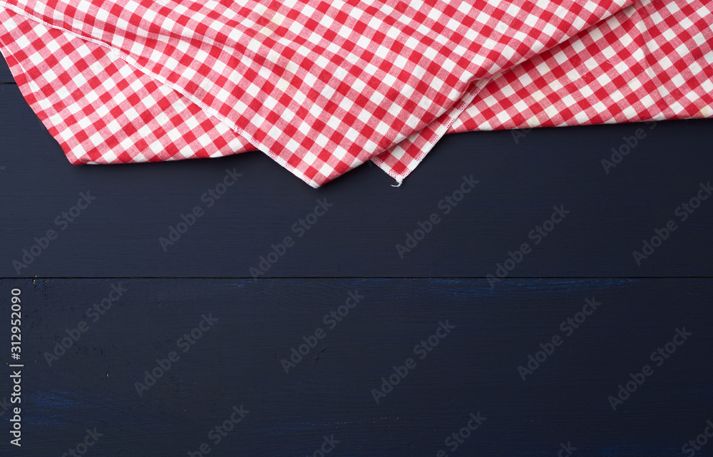 Fototapeta premium white red checkered kitchen towel on a blue wooden background