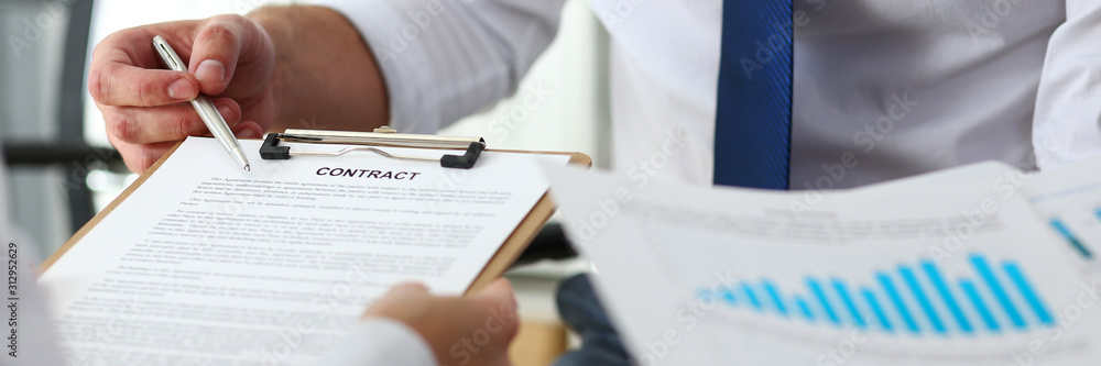 Male arm offer contract form on clipboard pad Male arm offer contract form on clipboard pad