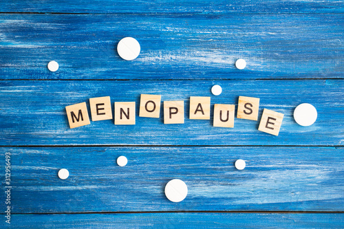 Concept. The inscription from the letters menopause. Symptoms of Menopause Harmonious changes in women older than 40 years.