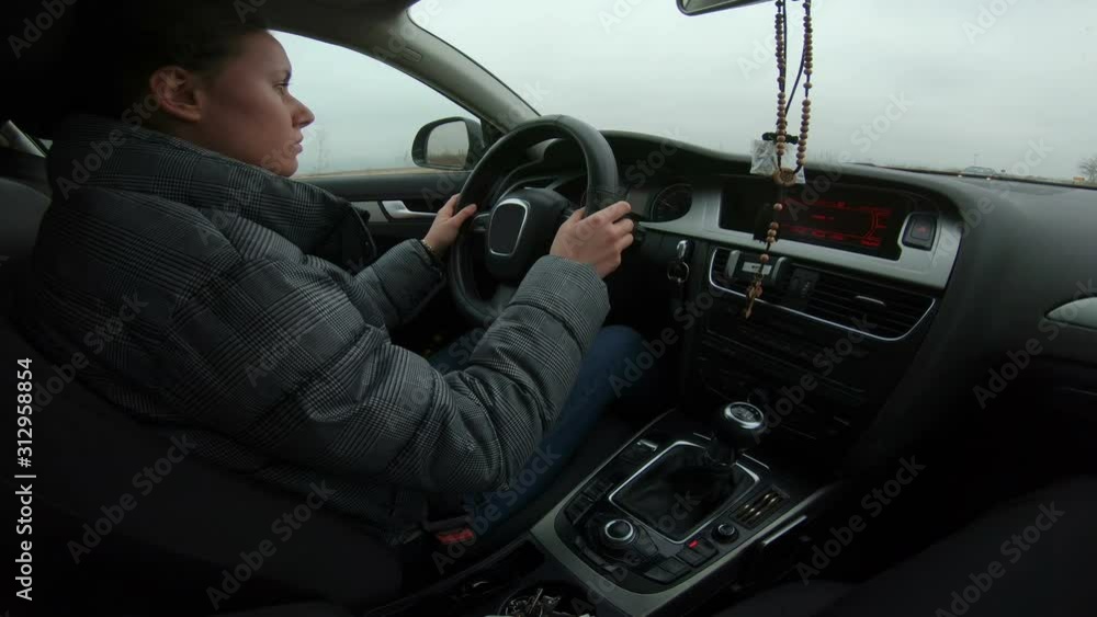 Portrait of beautiful Young Woman Driving Car through big cloudy City Portrait of beautiful Young Woman Driving Car through big cloudy City