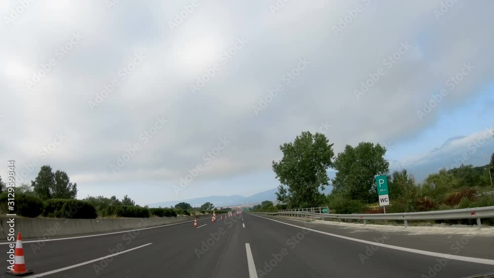 Drive POV on highway with roadwork signs and plastic pylons Drive POV on highway with roadwork signs and plastic pylons