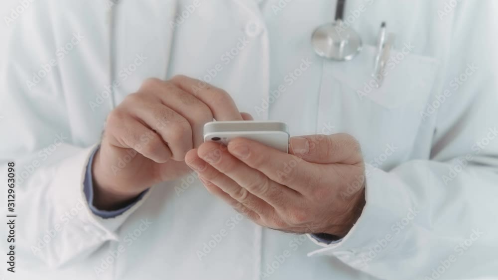 Doctor using a mobile phone. Texting. Lateral dolly. 