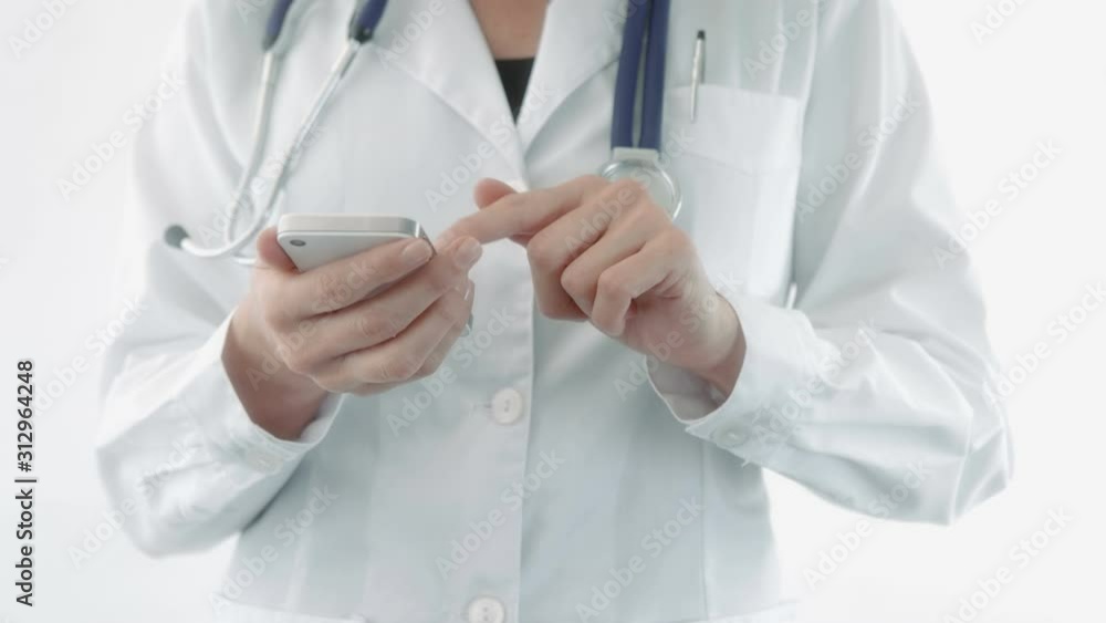 Doctor using a mobile phone and a tablet. Dolly. Various shots of a female and a male doctor using electronic devices. More options in my portfolio. Doctor using a mobile phone and a tablet. Dolly. Various shots of a female and a male doctor using electronic devices. More options in my portfolio.