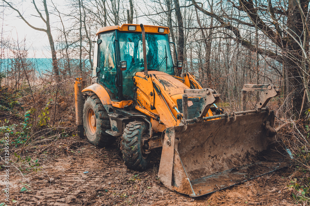 The excavator works in the forest in clearing the forest. The excavator works in the forest in clearing the forest.