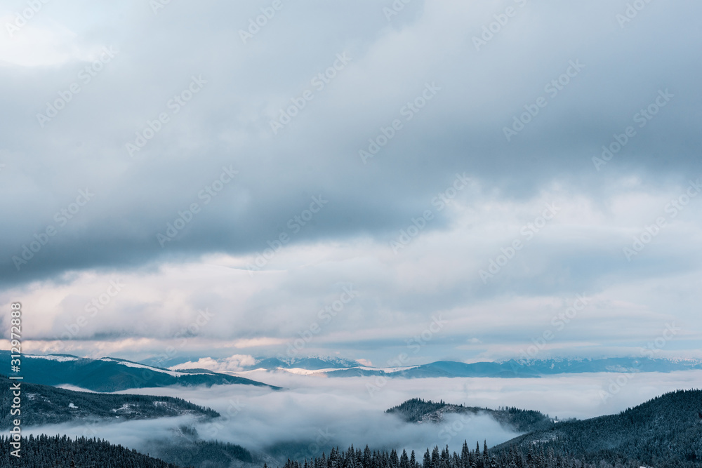 scenic view of snowy mountains with white fluffy clouds