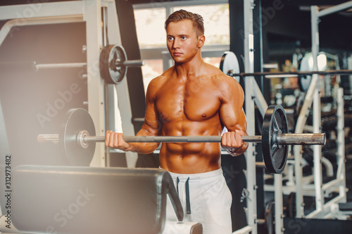 Young Handsome Muscular Men Exercising in the Gym