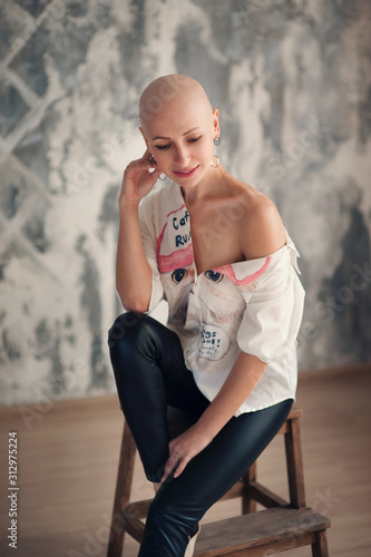 Portrait of beautiful middle woman patient with cancer with shaved head without hair. Emotions, hope in the eyes