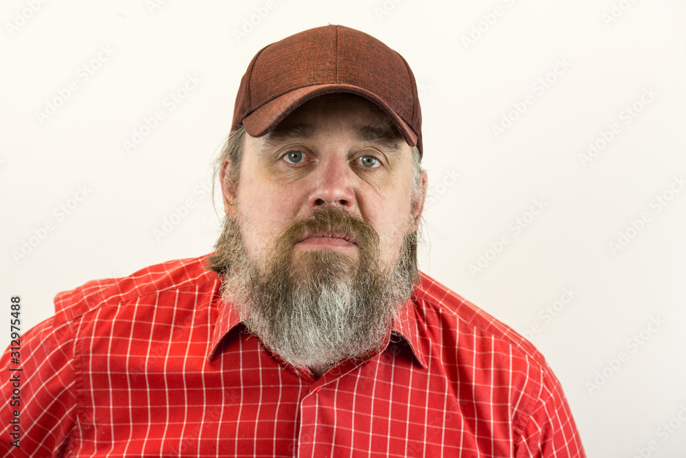 A brutal, bearded, stern man in a red shirt and baseball cap. A variety of emotions. Cruelty and masculinity. A brutal, bearded, stern man in a red shirt and baseball cap. A variety of emotions. Cruelty and masculinity.