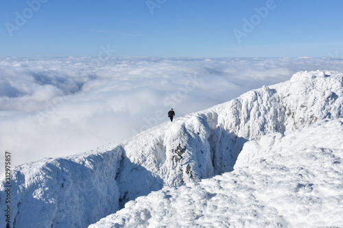 Lonely mountaineer get rest on snowy mountain high above the clouds. Happy climber enjoy in view from top of Dry Mountain, Serbia © Ivan