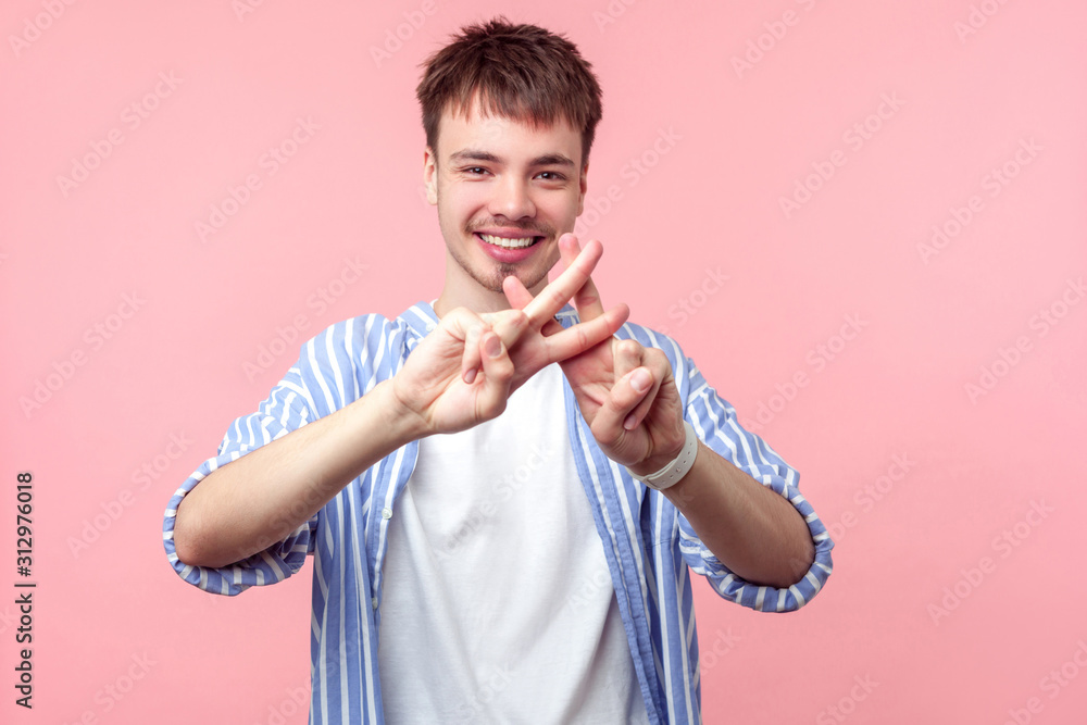 Portrait of cheerful brunette man with small beard and mustache in casual striped shirt showing hashtag gesture and looking at camera with toothy smile. indoor studio shot isolated on pink background Portrait of cheerful brunette man with small beard and mustache in casual striped shirt showing hashtag gesture and looking at camera with toothy smile. indoor studio shot isolated on pink background