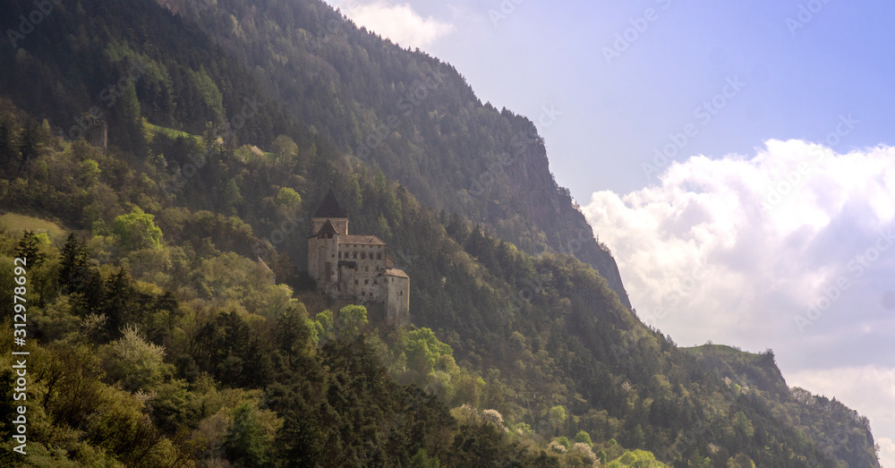fortress on a steep mountainside. forest mountains